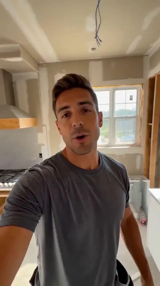 A contractor walking through a kitchen under construction
